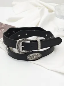 Close-up of vintage black western leather belt with silver floral buckle and metal studs