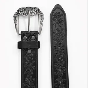Detail of bohemian black leather belt featuring floral embossing and a vintage silver buckle
