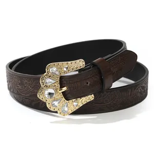 Dettaglio cintura bohémien in pelle marrone con goffratura e fibbia in strass