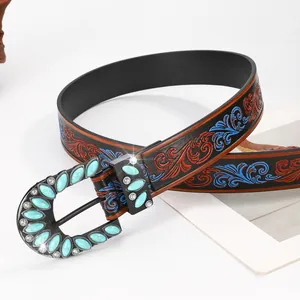 Close-up of bohemian leather belt with floral embossing and turquoise buckle detail
