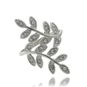 Dettaglio anello foglia argento con cristalli scintillanti su sfondo bianco riflesso