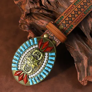 Close-up of Western vintage belt buckle with turquoise, pearls, and floral gold relief