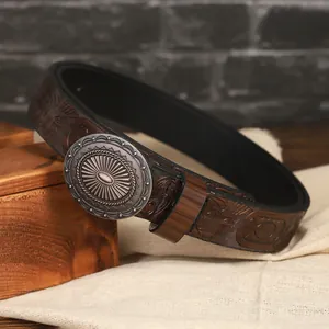 Dettaglio di cintura in pelle marrone vintage con goffratura etnica e fibbia in argento