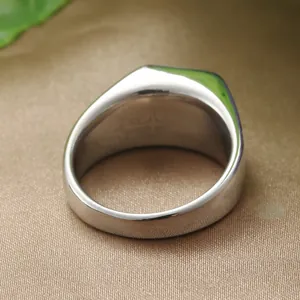 Polished silver stainless steel cross ring for men on elegant champagne silk background