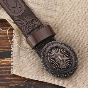 Dettaglio della fibbia in bronzo vintage e cintura in pelle goffrata con stile etnico