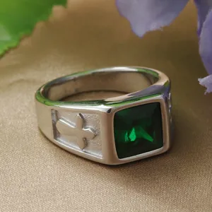 Detail of square emerald stone and cross engraving on vintage stainless steel ring
