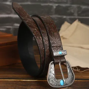 Dettaglio cintura in pelle western con goffratura floreale e fibbia turchese