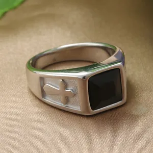 Macro shot of men's vintage steel ring with black onyx and embossed cross detail