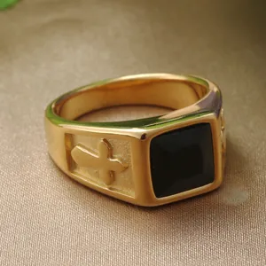 Close-up of gold stainless steel ring featuring a black square stone and cross relief