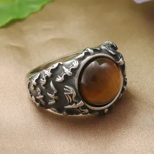 Détail macro d'une bague punk vintage avec pierre œil de tigre et gravures en relief