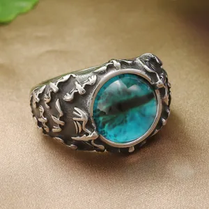 Vue macro d'une bague œil de dragon rétro avec pierre verte sur satin doré