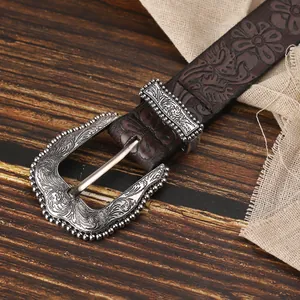 Dettaglio cintura in pelle bohémien con goffratura floreale vintage e fibbia in argento inciso
