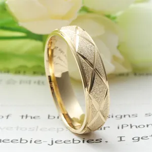 Detailed macro view of gold titanium steel ring with matte finish and rhombus X engraving