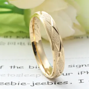 Macro detail of gold frosted titanium steel ring with geometric X-pattern cross engraving