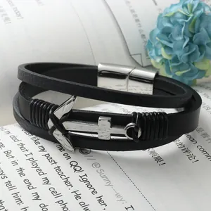 Bracciale nautico in pelle nera con ancora e chiusura magnetica lucida su sfondo floreale