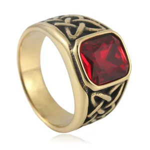 Macro detail of gold stainless steel ring with square red stone and Celtic knots