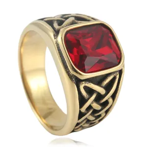 Macro detail of men's vintage gold ring featuring a red square gem and Celtic knot texture
