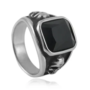 Detail of vintage steel ring with black square stone and side skull engravings