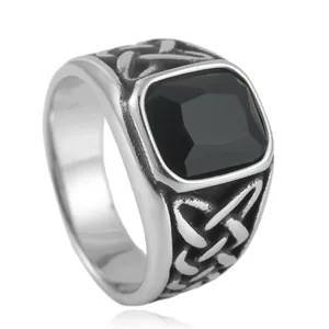 Macro shot of silver punk ring with square black stone and Celtic knot details