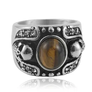 Detalle macro de anillo punk calavera con piedra ojo de tigre y acero envejecido