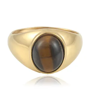 Macro shot of polished gold band ring featuring a large oval brown tiger eye gemstone
