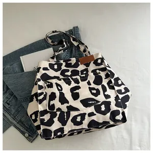 Détail du sac cabas en nylon léopard avec empiècement cuir et poche avant à rivets