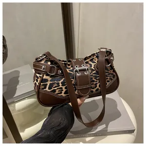 Detail of leopard print underarm bag with vintage silver rivets and adjustable strap