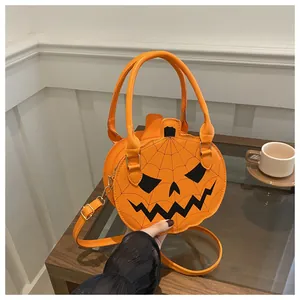 Detail of pumpkin crossbody bag with spider web stitching and classic jack-o'-lantern face