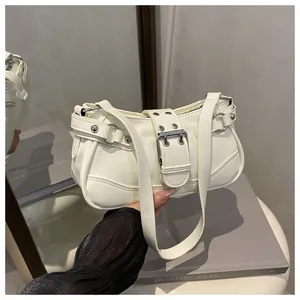 Close-up of white motorcycle style underarm bag with silver buckles and metal rivets