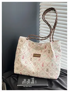 Dettaglio della borsa tote trapuntata con stampe di orsetti e manico intrecciato marrone