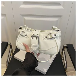 Detail of creamy white leather crescent underarm bag with silver buckle and studs