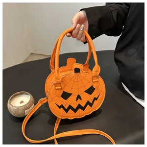 Detail of pumpkin-shaped crossbody bag featuring orange faux leather and classic jack-o'-lantern face