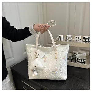 Détail du grand sac cabas blanc matelassé avec broderie papillon et pendentif nuage doux