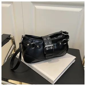 Detail of black punk shoulder bag with silver grommets and vintage buckle design