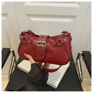 Detailed shot of dark red crescent bag featuring silver metal buckle and rivets