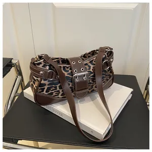 Close-up of leopard print fabric underarm bag with silver rivets and leather straps