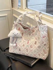 Borsa tote trapuntata con stampe di animali e manici intrecciati sopra dei libri