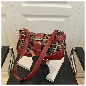 Close-up of leopard print fabric with burgundy leather trim and silver buckle details