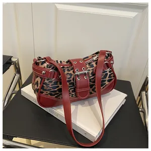 Detail of leopard print hobo bag with red-brown leather trim and punk metal buckle