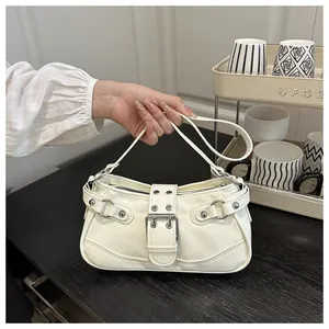 Close-up of cream underarm crescent bag with silver rivets and vintage buckle detail