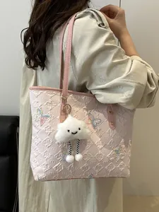 Grand sac cabas rose avec broderie papillon et pendentif nuage porté par un mannequin