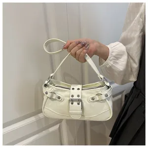 Detail of cream white faux leather underarm bag with Y2K rivets and silver buckles