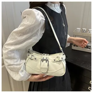 Detail of white Y2K style hobo bag with silver rivets and buckles on a female model