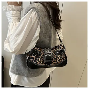 Detail of leopard print shoulder bag featuring silver metal buckles and rivets