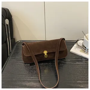 Detail view of brown frosted leather shoulder bag with vintage gold metal buckle closure