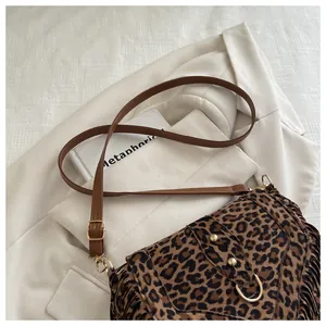Detail of leopard print crossbody bag with suede fringes and golden rivets decoration