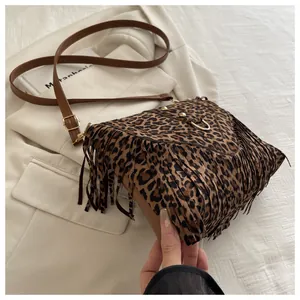 Detail of leopard print crossbody bag with suede fringes and retro metal rivets