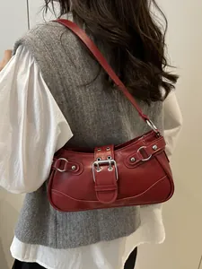 Retro red faux leather underarm bag with silver studs and Y2K metal buckle on a shoulder