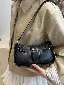 Retro black crescent underarm bag with silver rivets and studs on a model