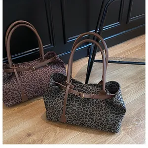 Detail of leopard print suede tote bags with leather handles and textured fabric